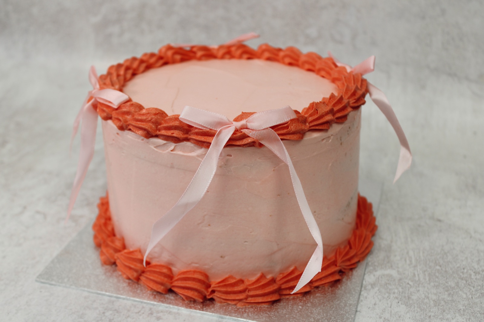 Pink celebration cake with ribbon from Knotts Bakery